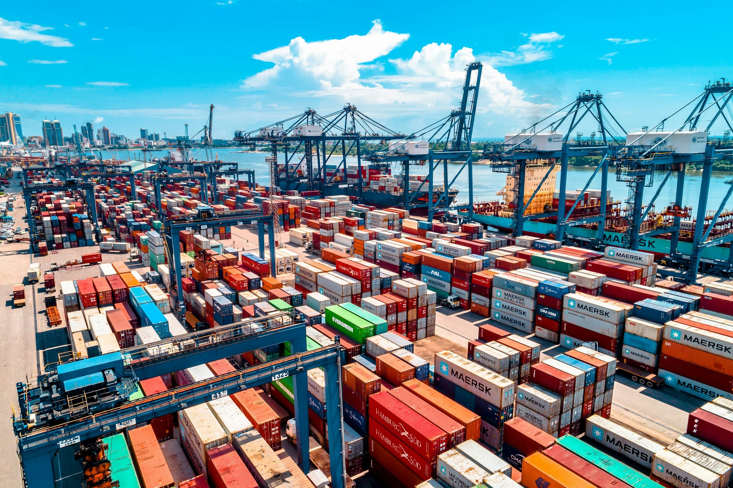 Aerial view of a busy container port with cranes and stacked shipping containers