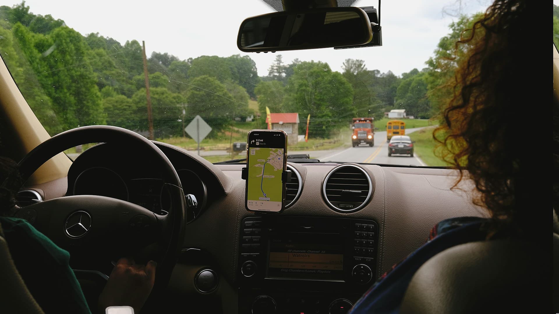 Driver following a live route map on a phone mounted to the dashboard